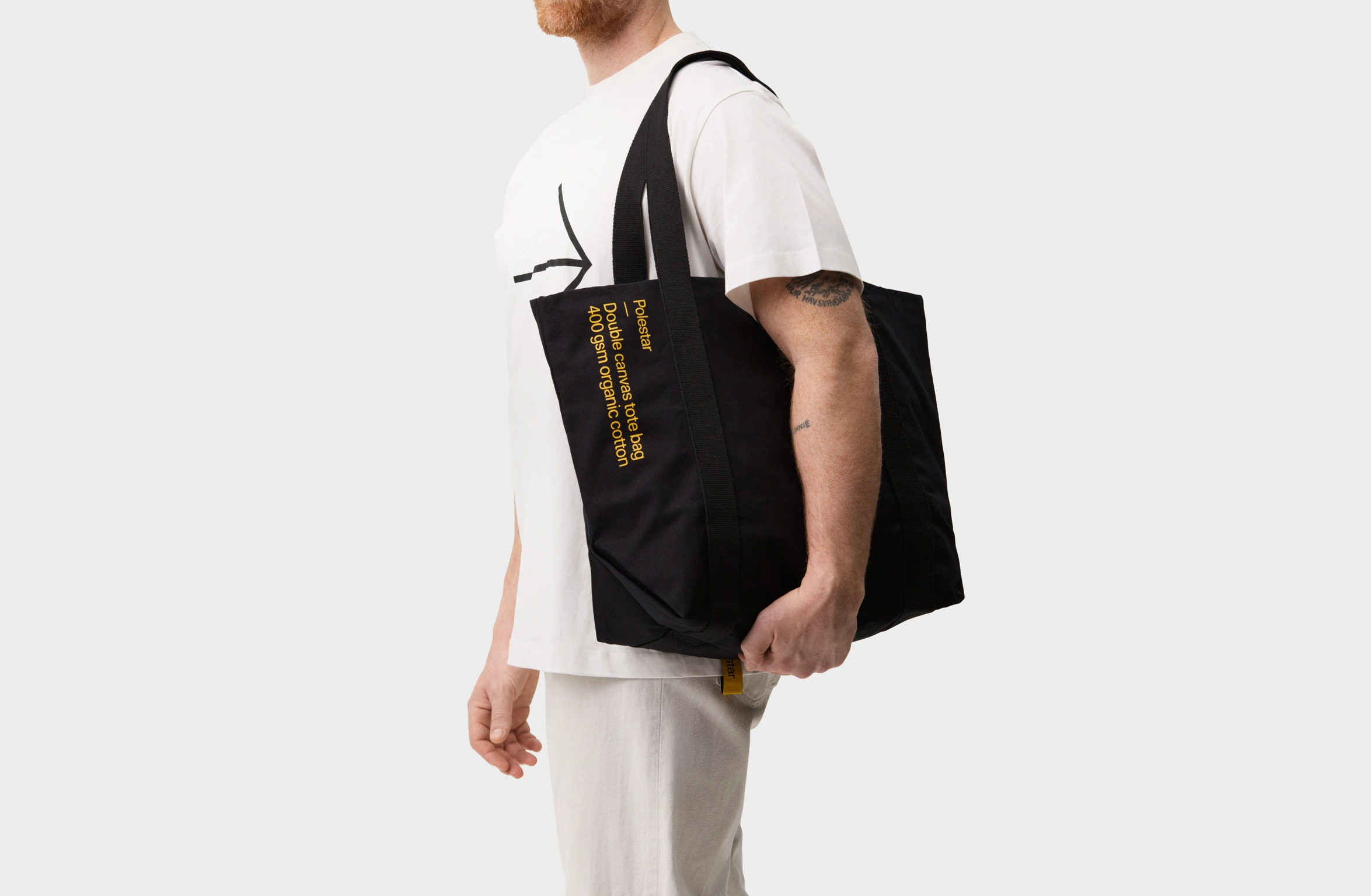 Black tote bag with a small yellow Polestar wordmark
