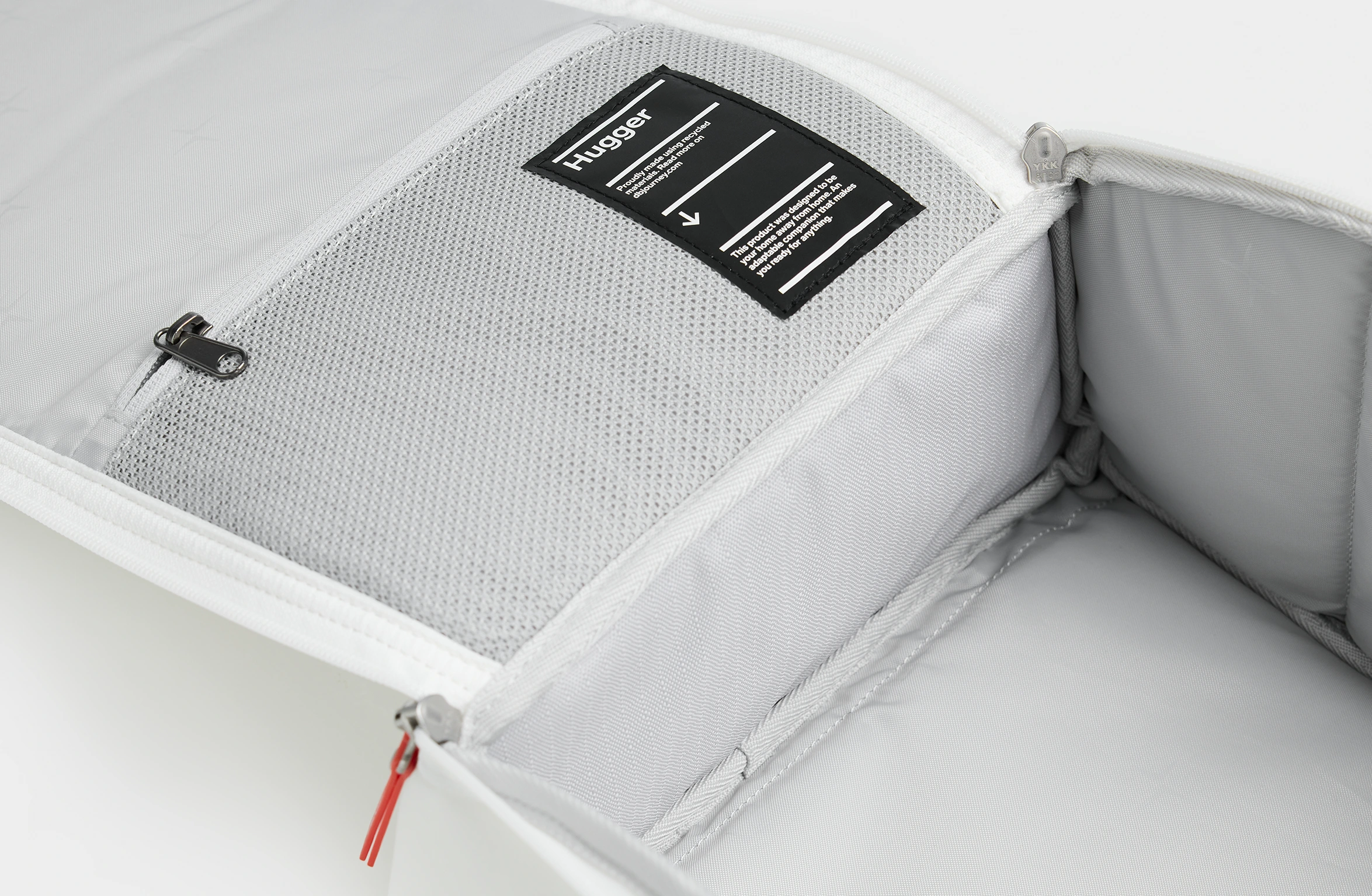 Weißer Rucksack mit orangefarbenen Details, gepolsterten Trägern und seitlich angebrachtem Branding von Polestar und Db