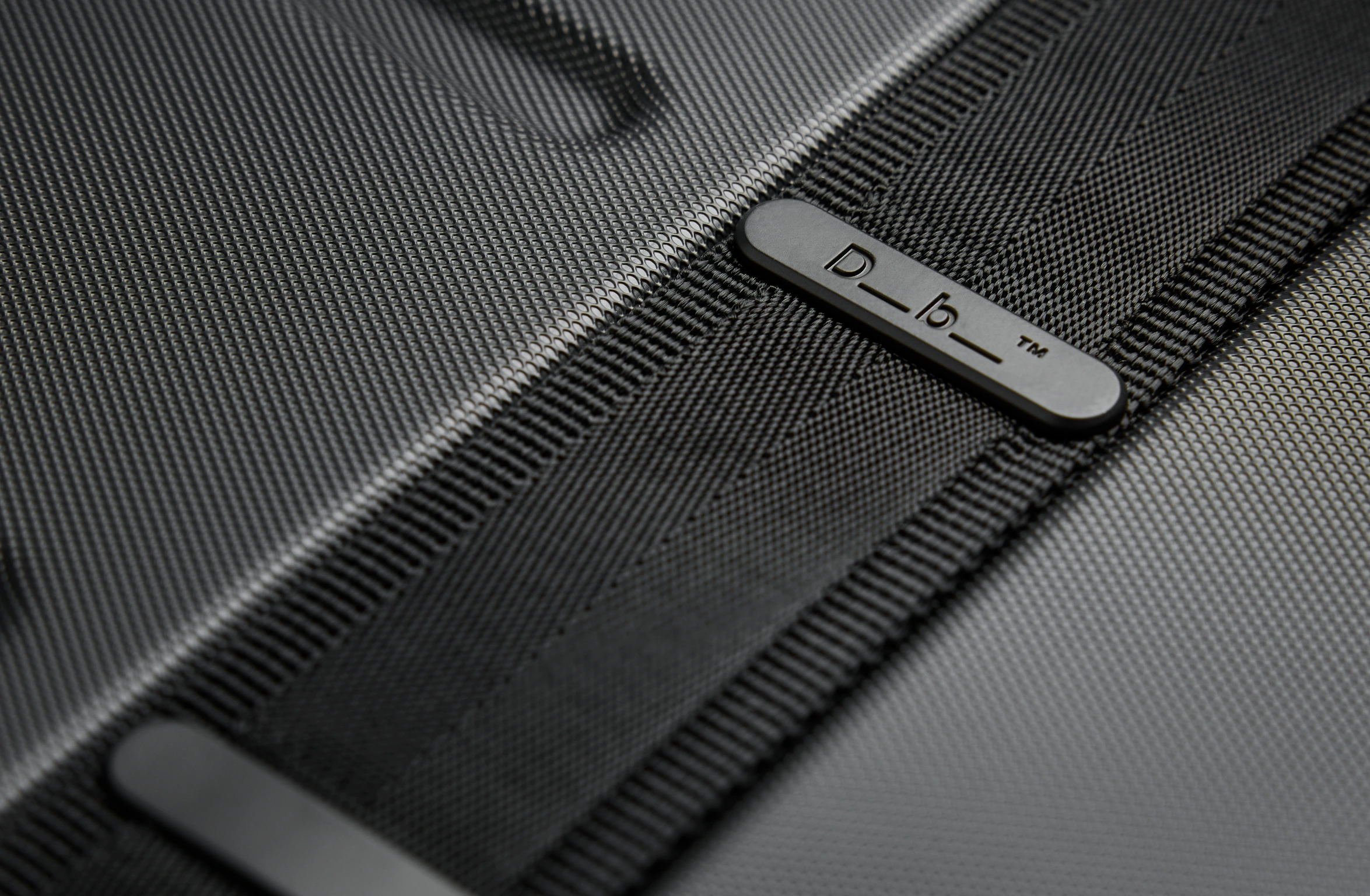 Black hard-shell suitcase with reinforced edges, secure locks, and Polestar x Db branding on the side.