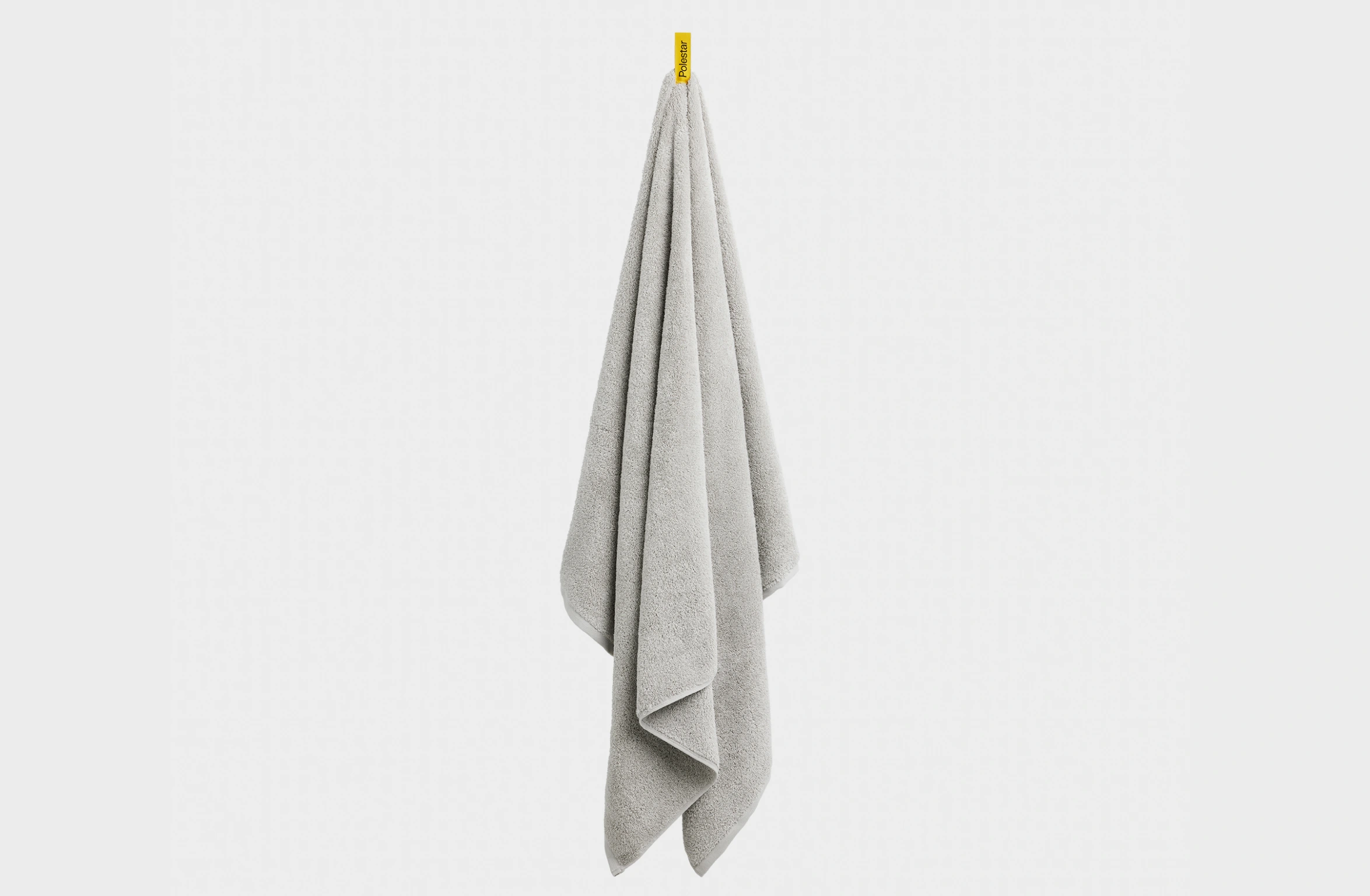 Gray towel with a yellow side tag with black Polestar wordmark