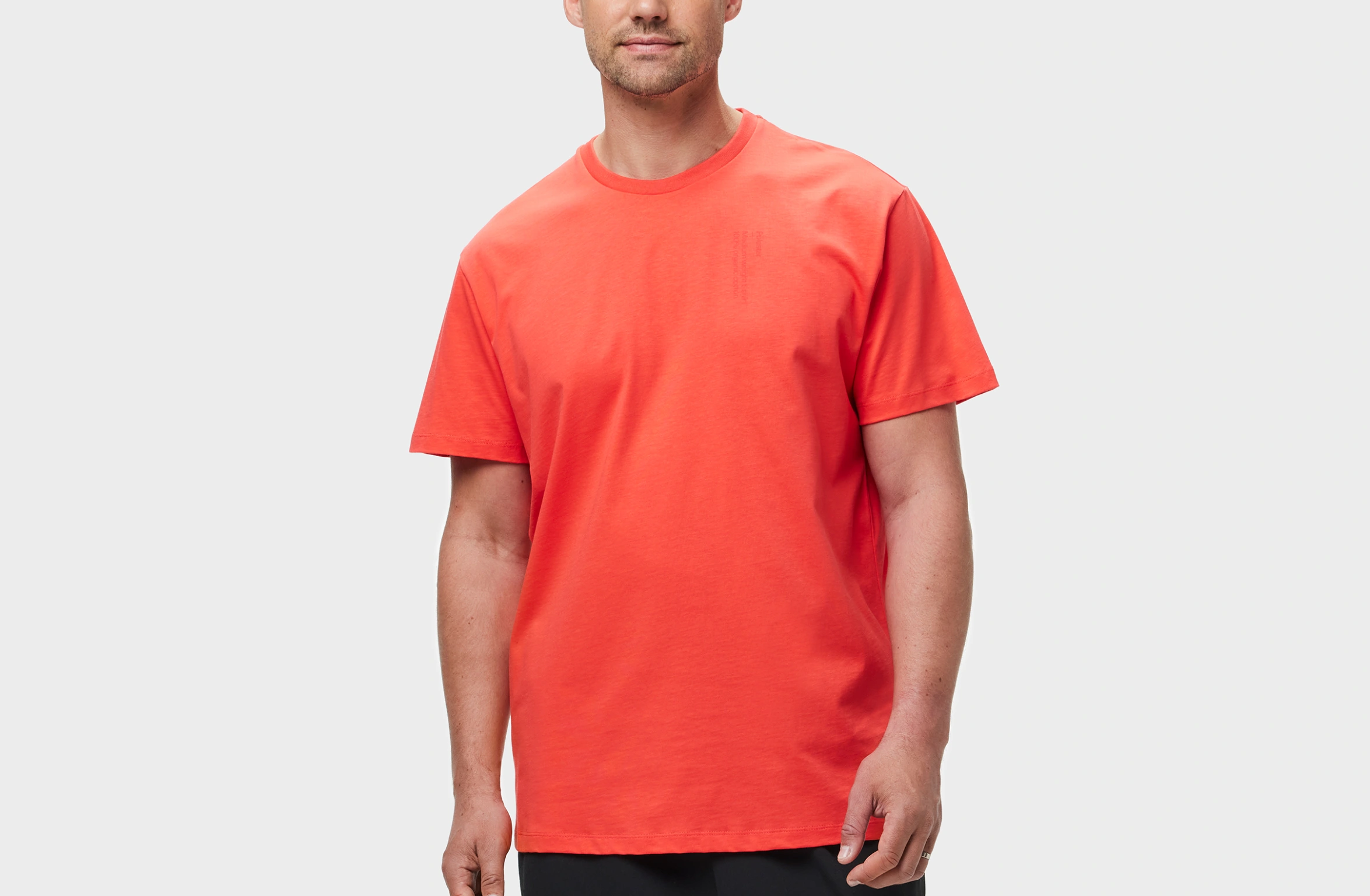 Red t-shirt with tone-on-tone Polestar wordmark on the left chest and small white Polestar symbol on the back