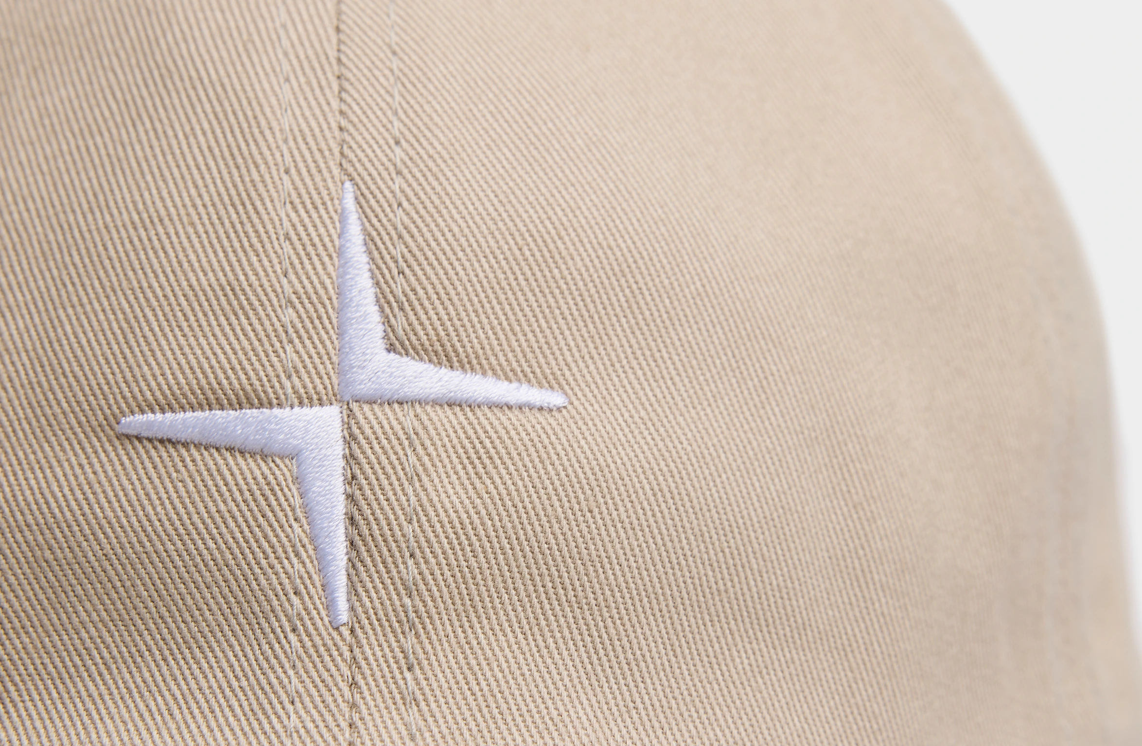 Beige pet met wit Polestar-logo op de voorkant