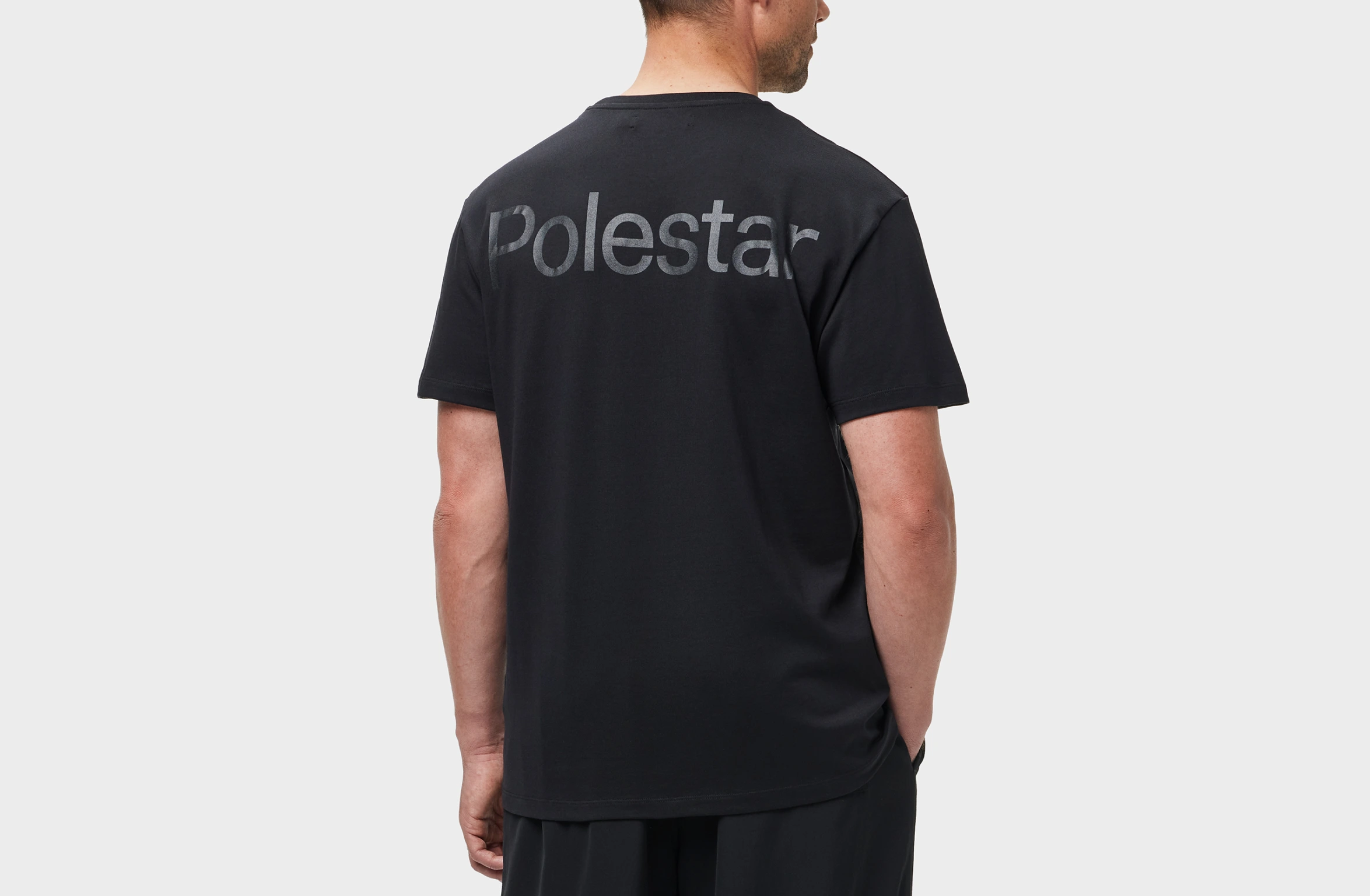 Sort T-shirt med stort tone-i-tone Polestar-ordmærke på den øverste del af ryggen