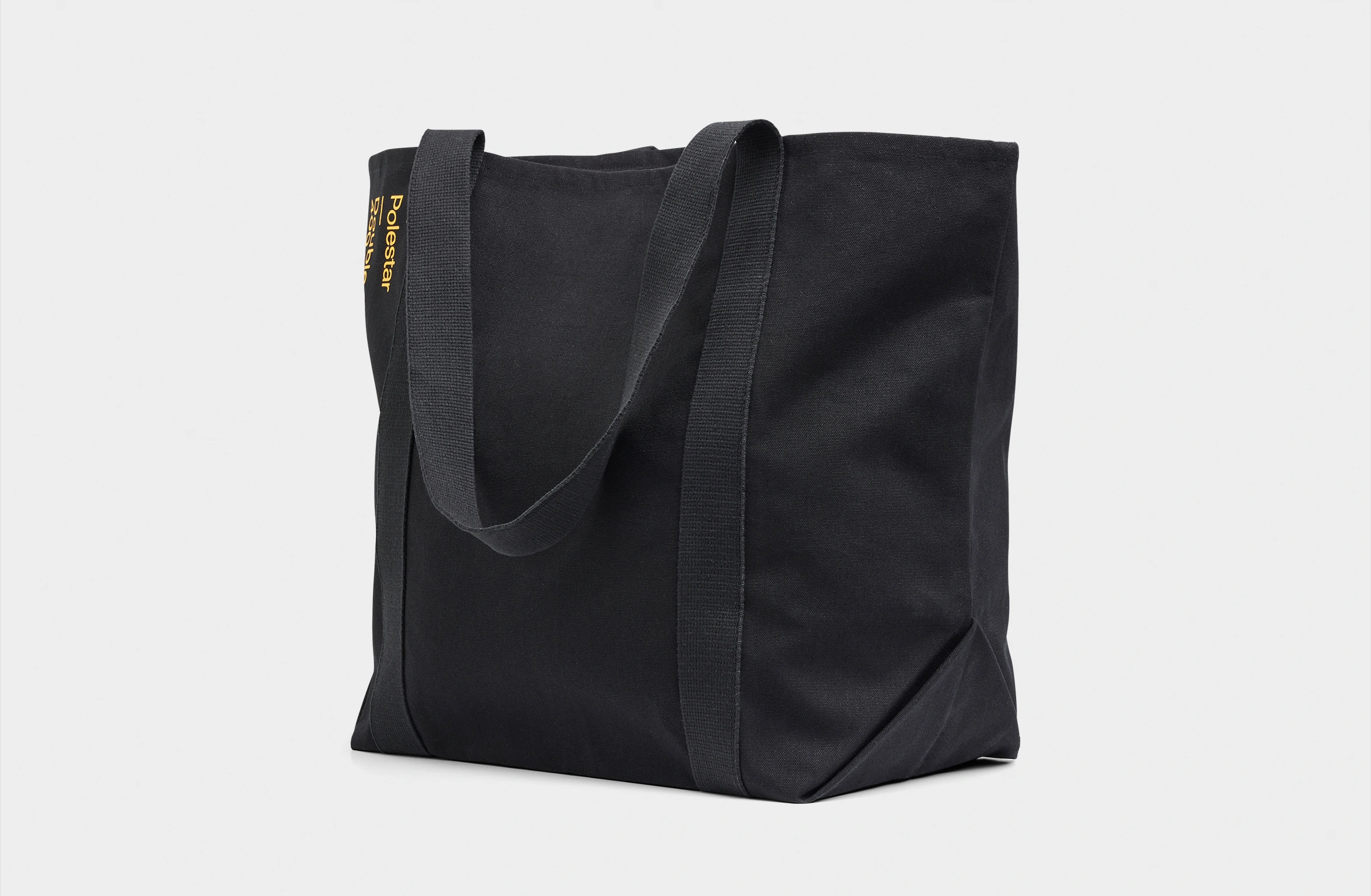 Black tote bag with a small yellow Polestar wordmark