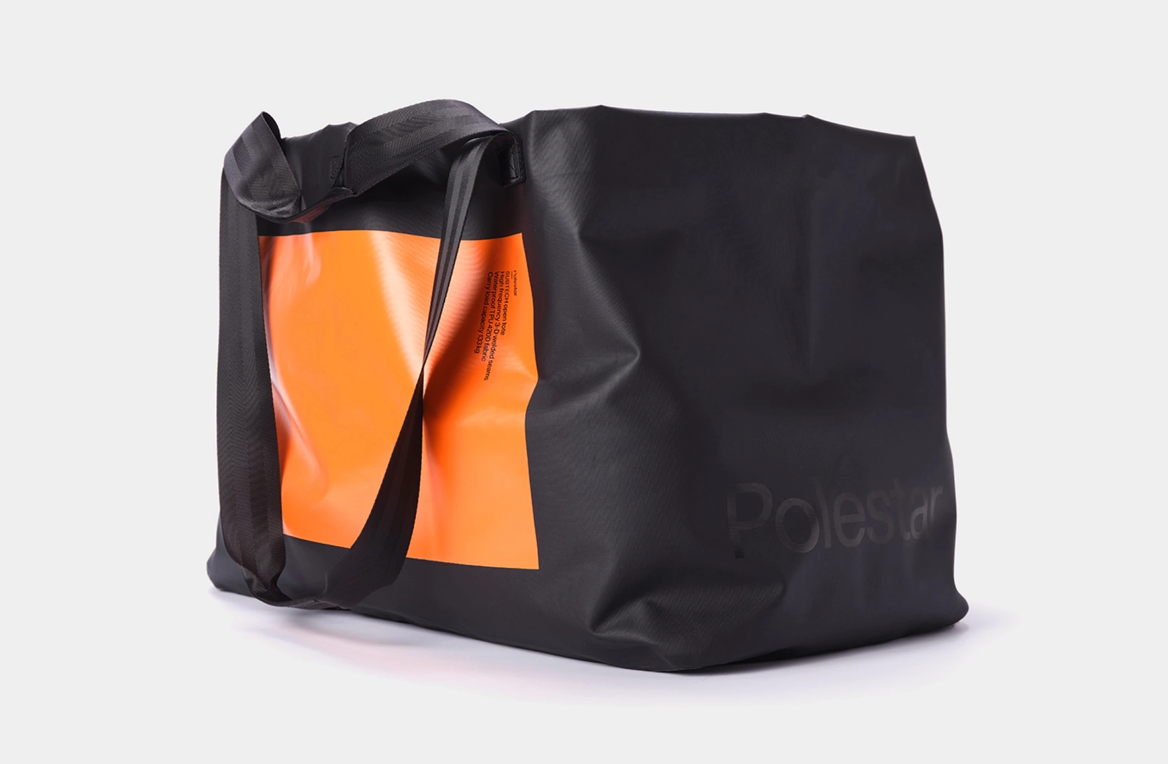 Black waterproof open tote bag with big orange rectangular deisgn with smal Polestar wordmark on the front