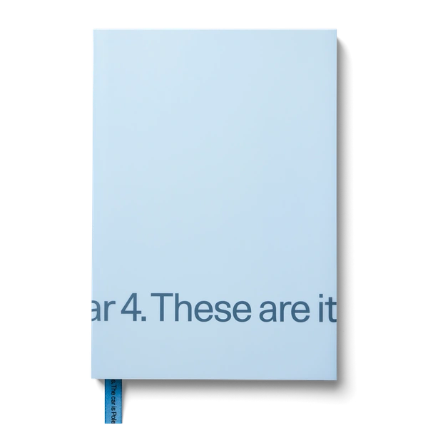 A light blue book with subtle embossed text and a blue bookmark.