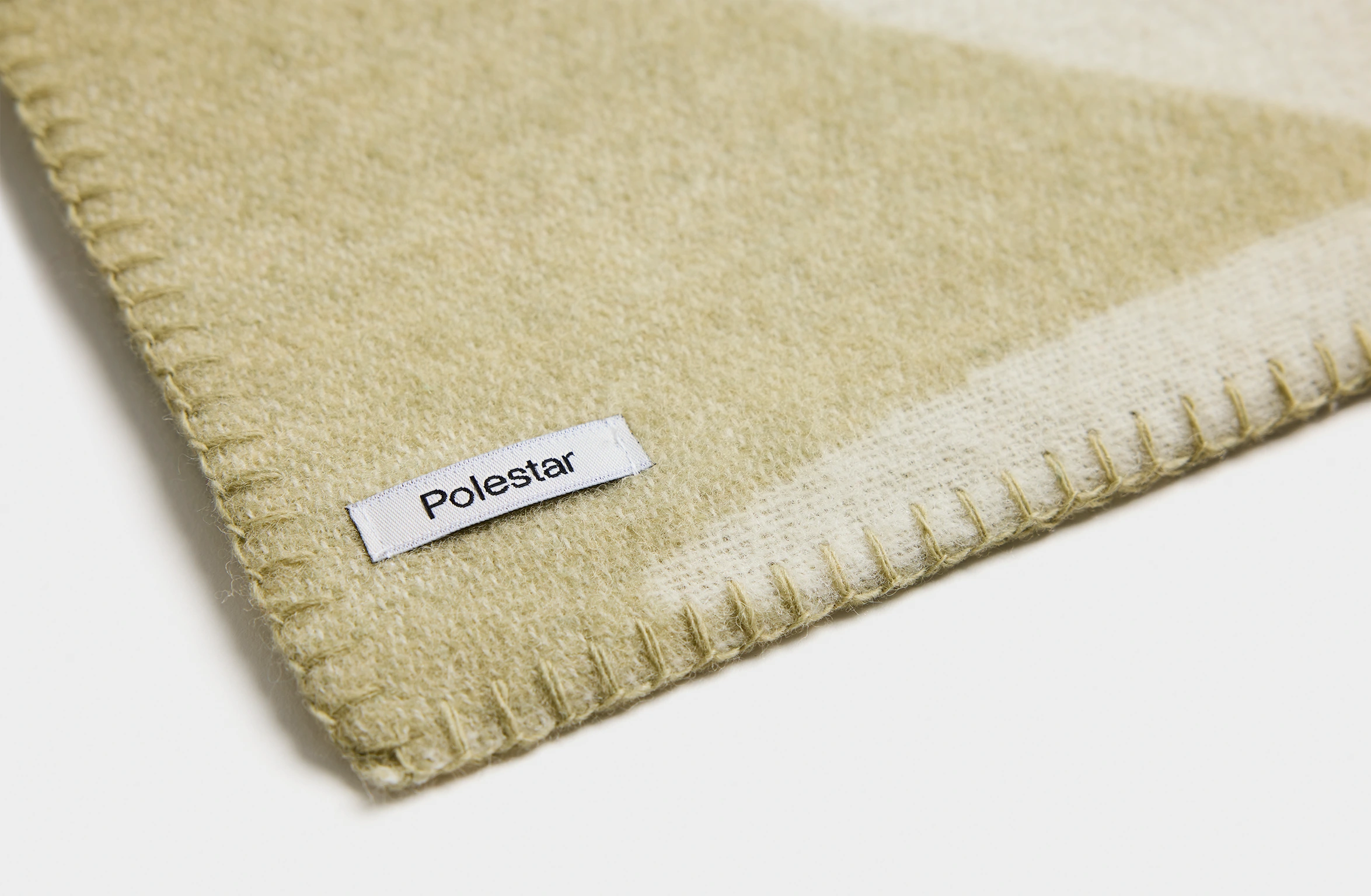 Merino wool blanket in sage green with an abstract pattern