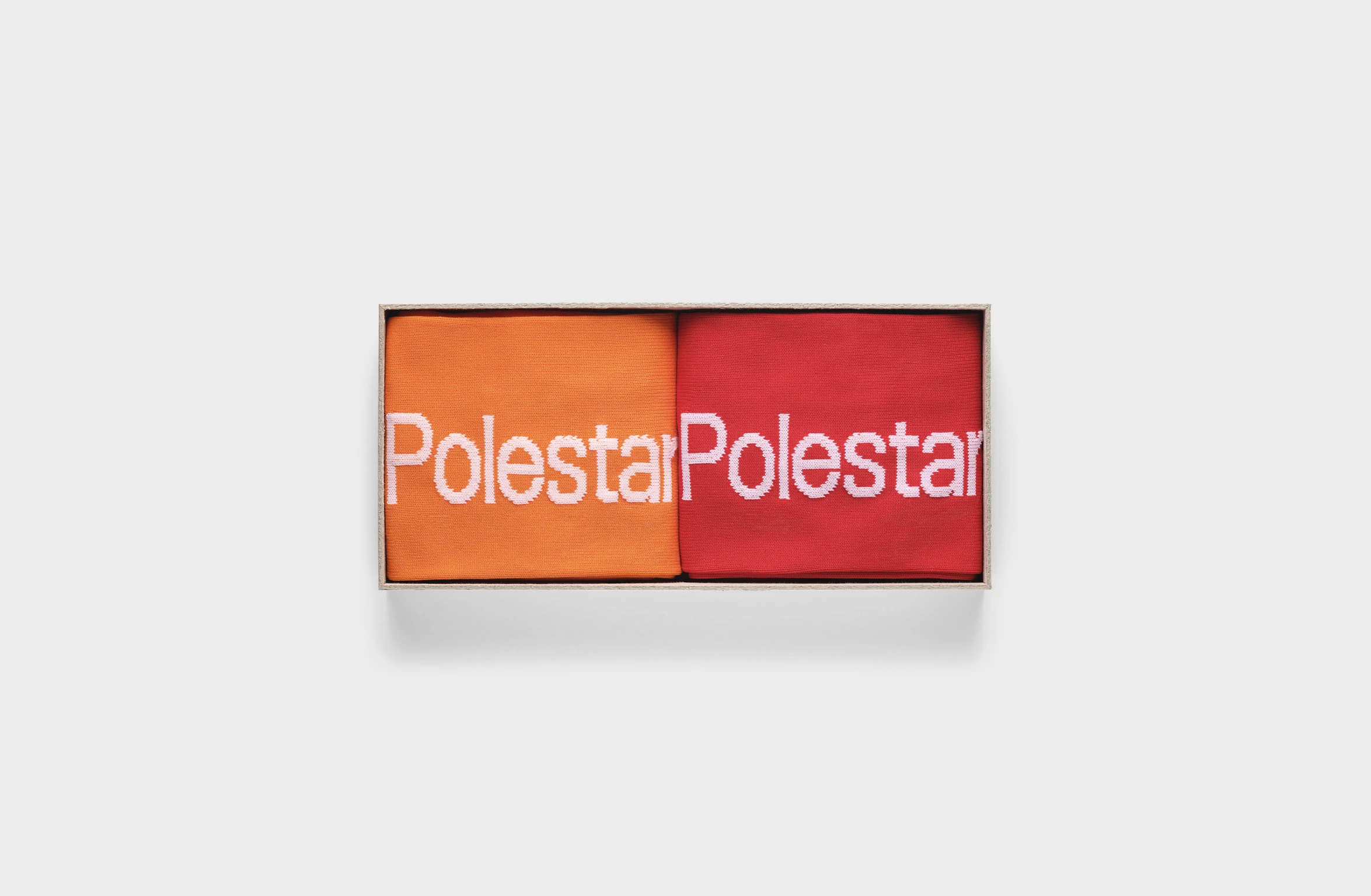 Zwei Paar Socken mit Polestar Aufschrift Je eins in Orange und Rot
