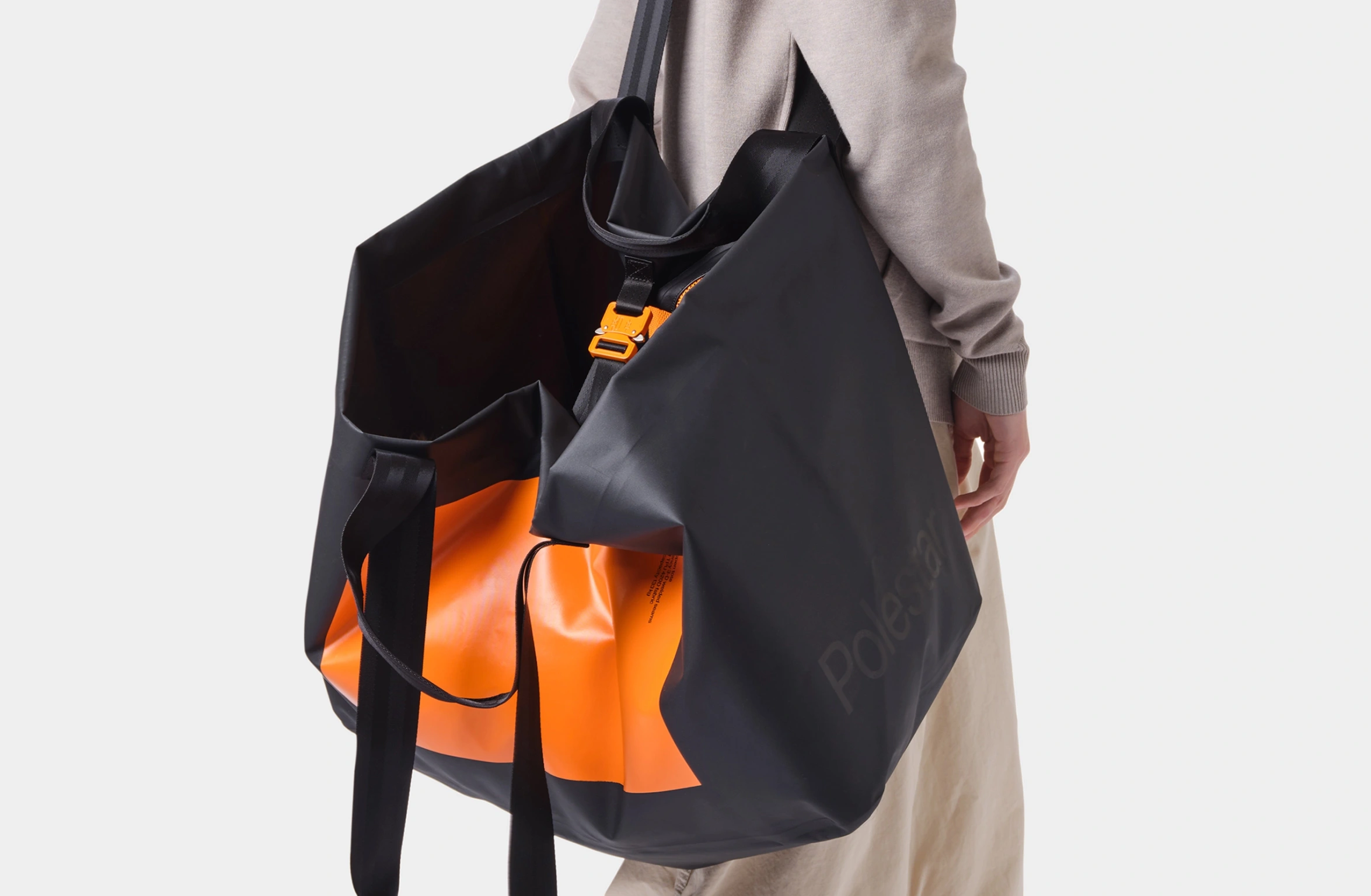Wasserdichte offene Tragetasche in Schwarz mit großem Rechteck in Orange und kleinem Polestar Schriftzug vorn