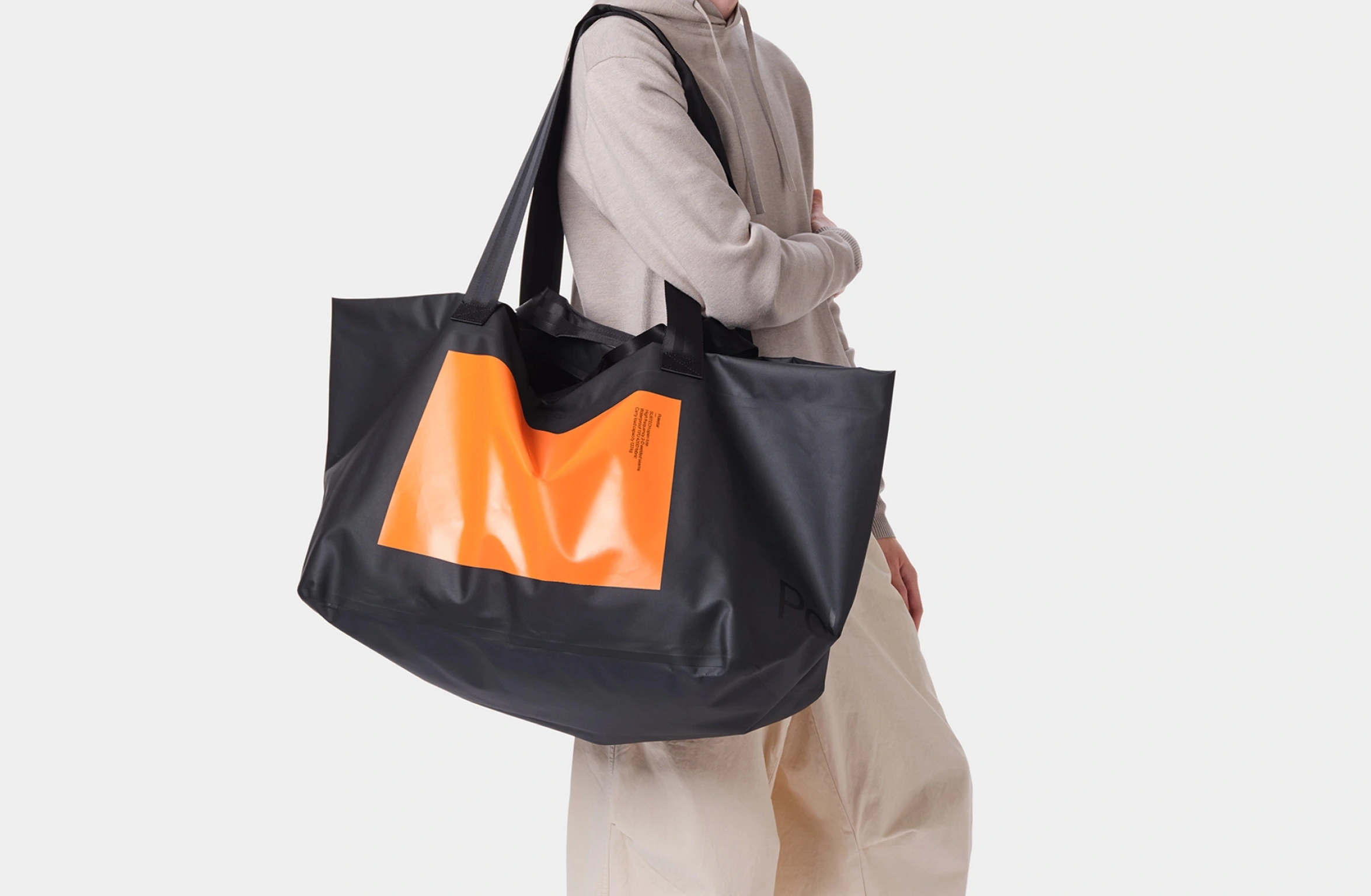 Black waterproof open tote bag with big orange rectangular deisgn with smal Polestar wordmark on the front