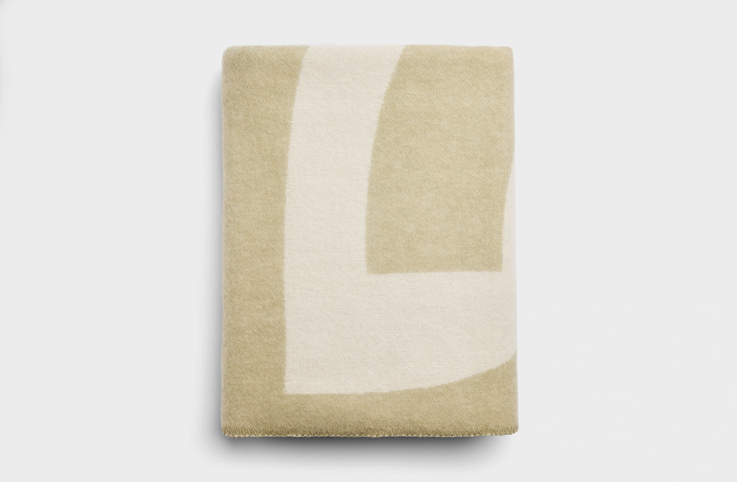 Merino wool blanket in sage green with an abstract pattern