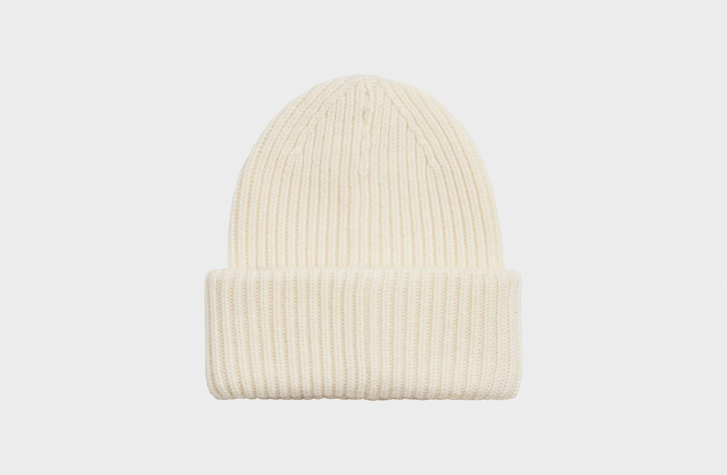 Beige knitted cashmere beanie with a small orange Polestar detail