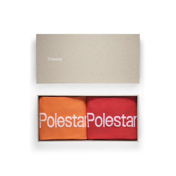 Paket med strumpor med Polestar-ordmärke. Ett par i orange och ett par i rött