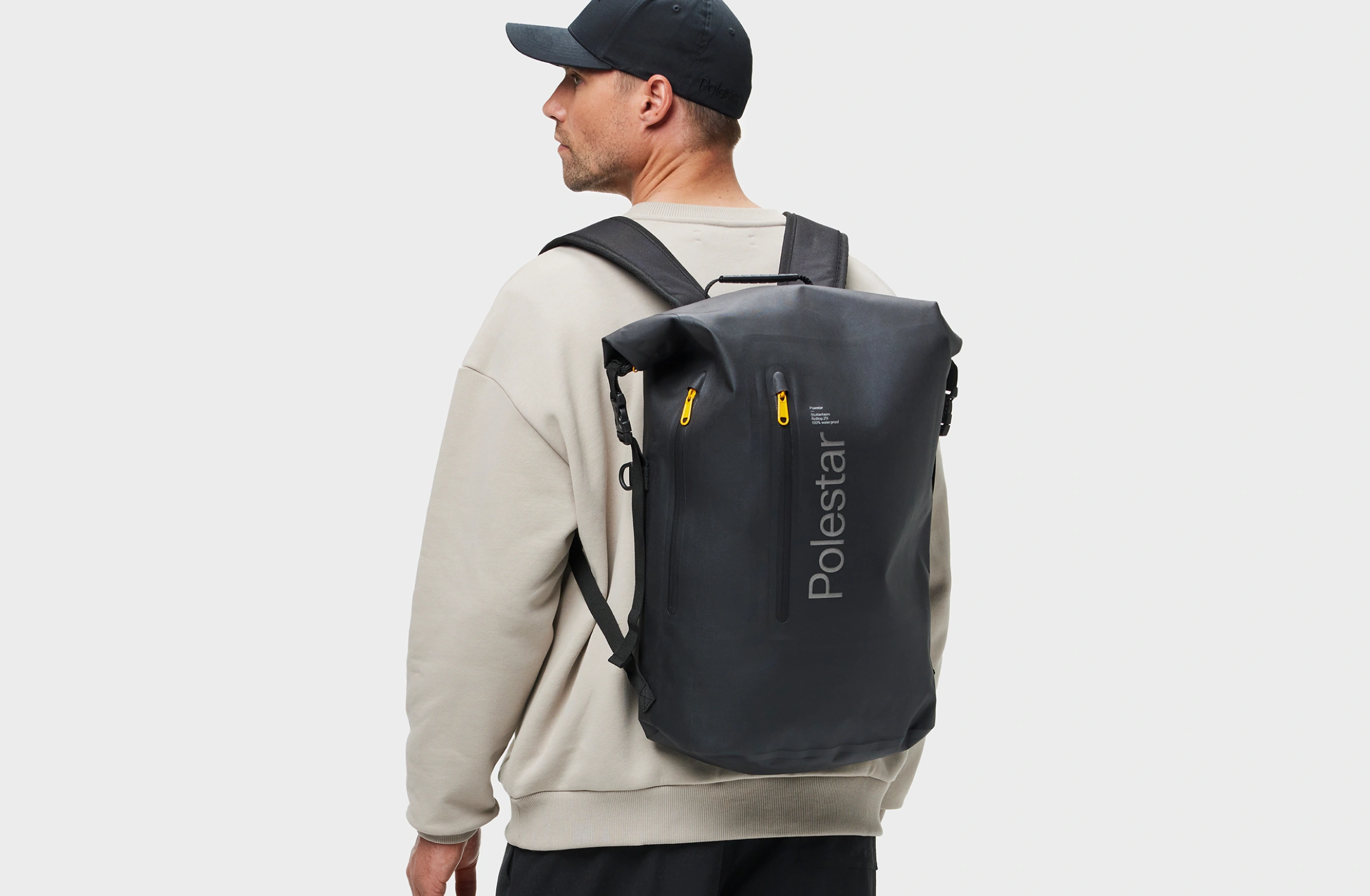 Zwarte waterdichte rolltop rugzak met gele ritstrekkers en ton-sur-ton Polestar-woordmerk op de voorkant.