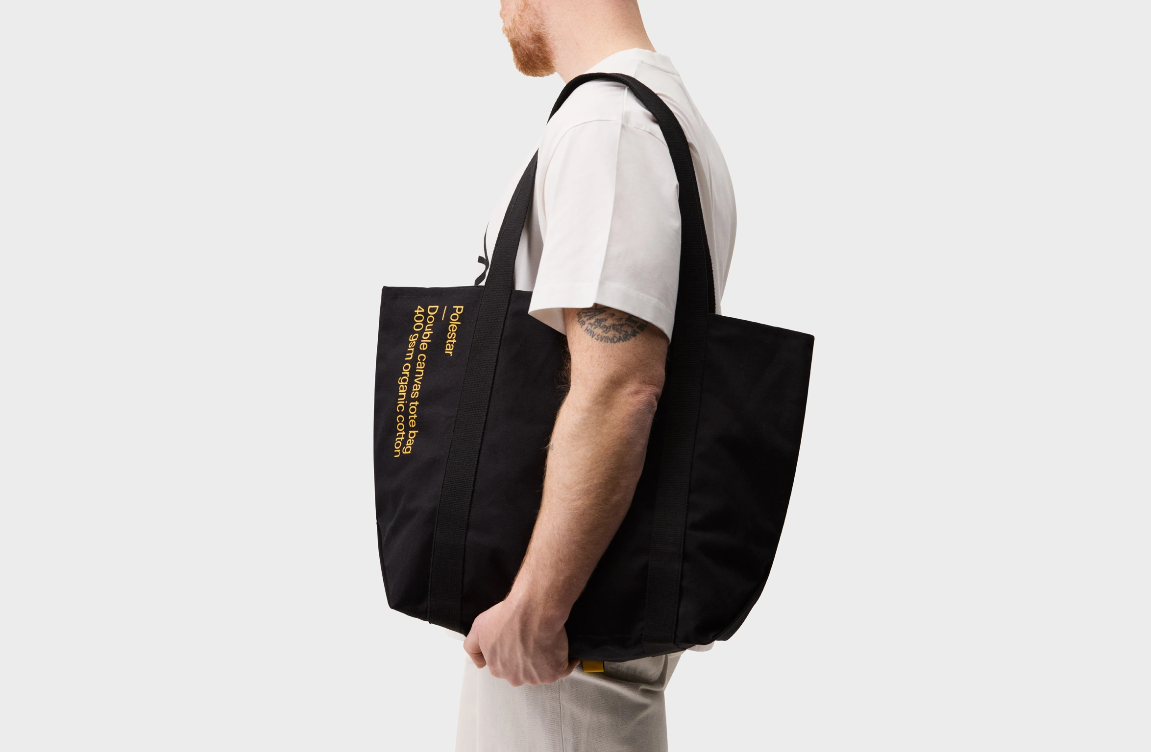Black tote bag with a small yellow Polestar wordmark