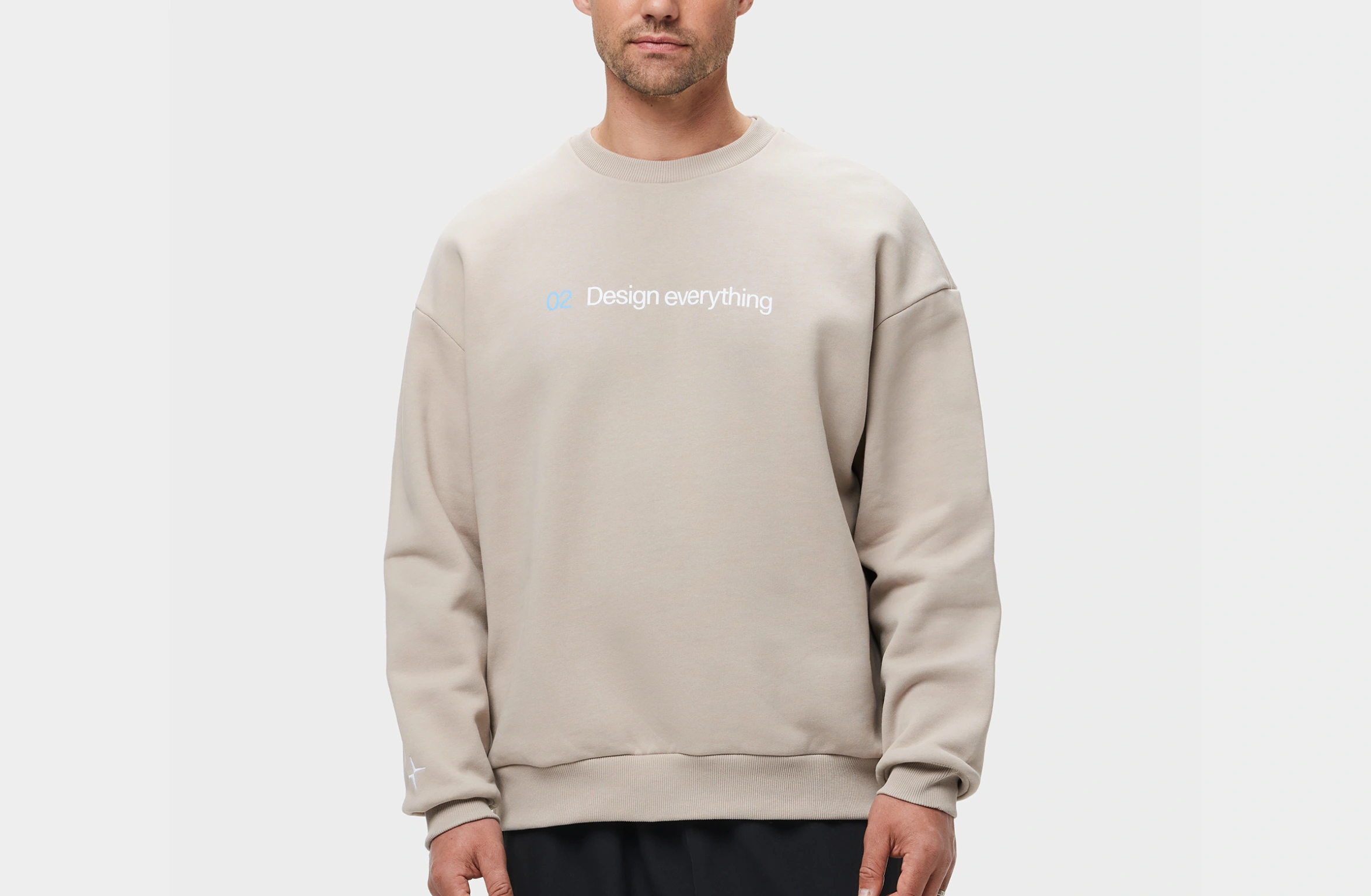 Beige genser med teksten "02 Design everything" på forsiden