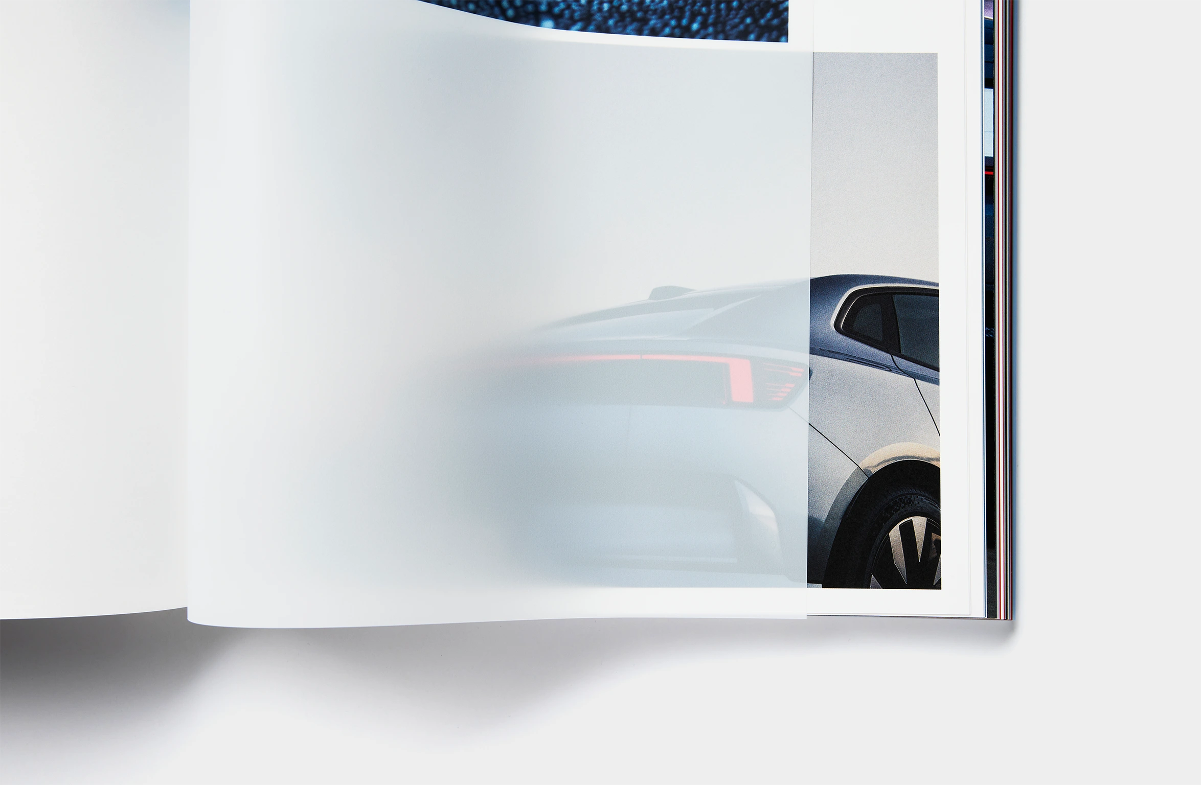 A light blue book with subtle embossed text and a blue bookmark.