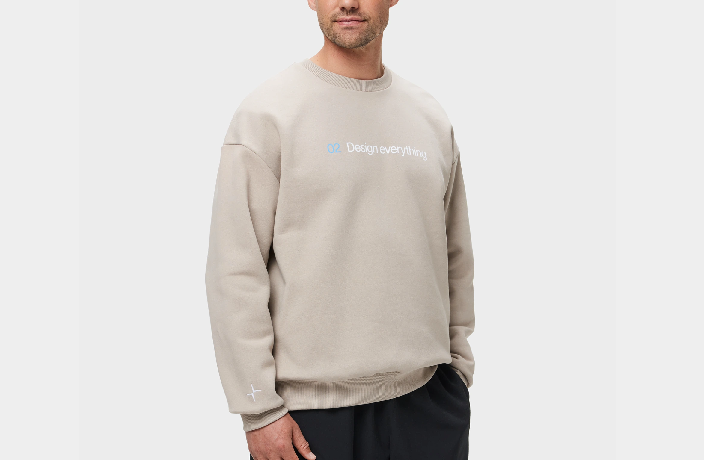 Beige sweater med teksten "02 Design everything" på forsiden