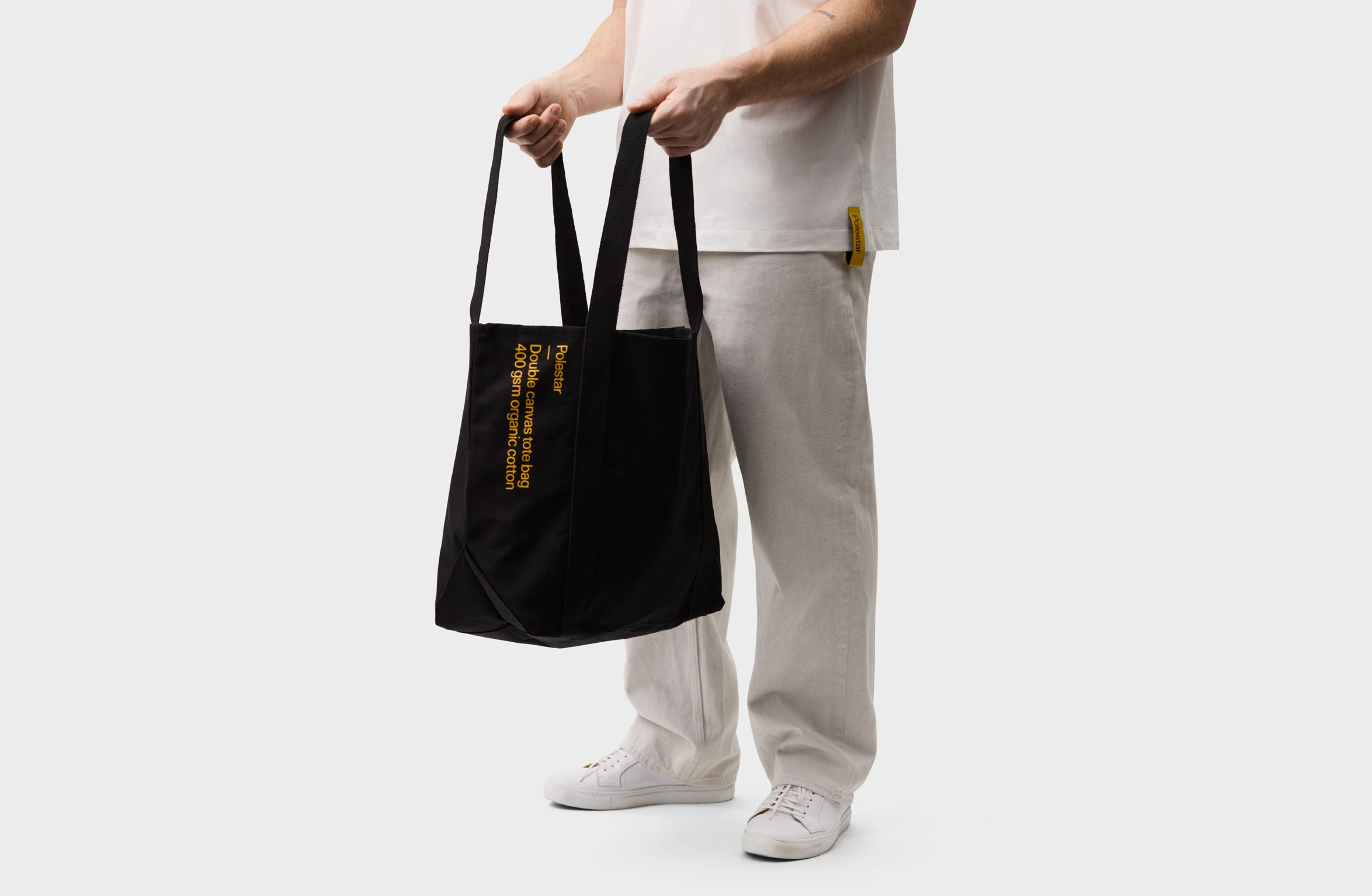 Black tote bag with a small yellow Polestar wordmark
