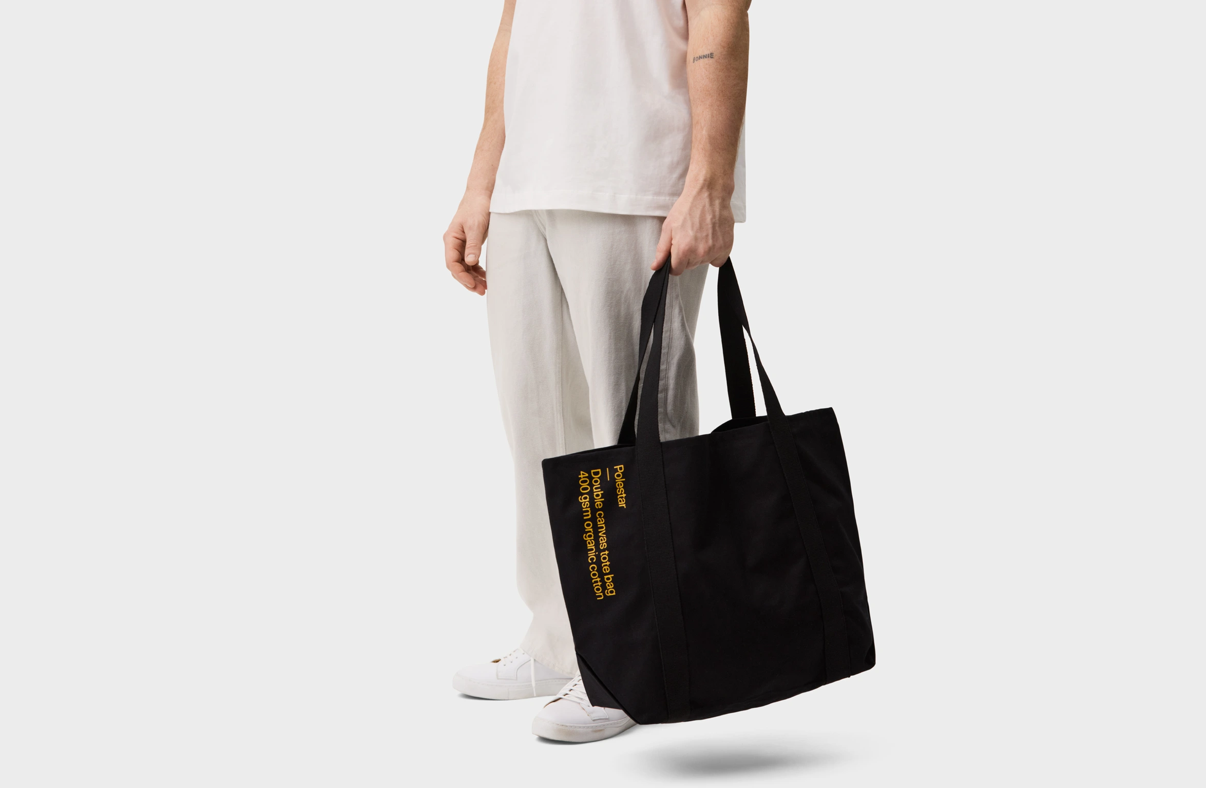 Black tote bag with a small yellow Polestar wordmark