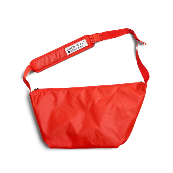 Rote Sling Bag mit verstellbarem Schultergurt und Markenetikett auf dem Schulterpolster