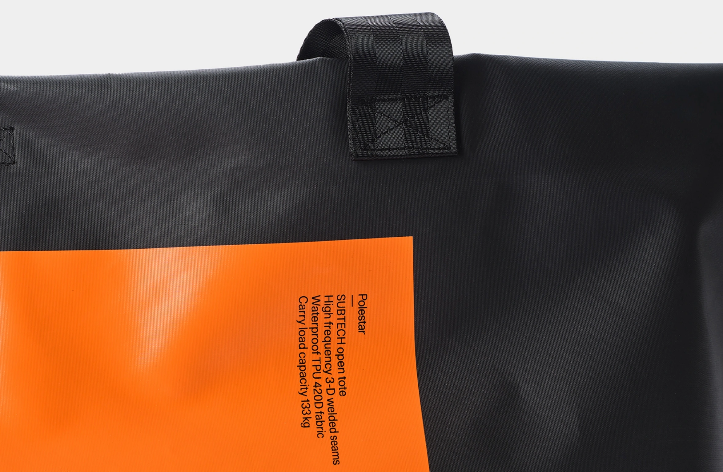 Sort vandtæt åben mulepose med stort orange rektangulært design og lille Polestar-ordmærke på forsiden