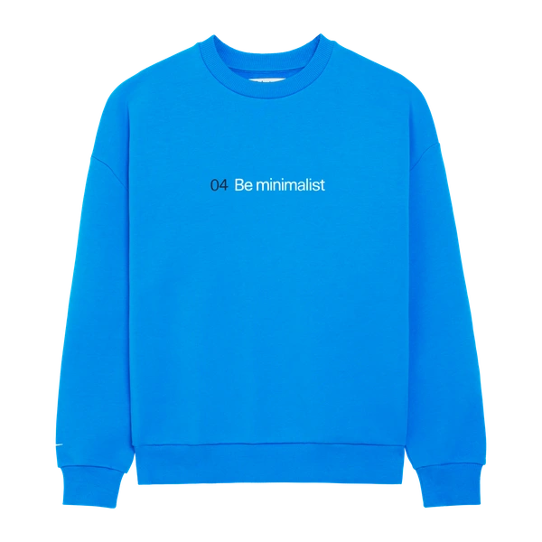 Blue sweater thiw the text "04 Be minimalist" on the front