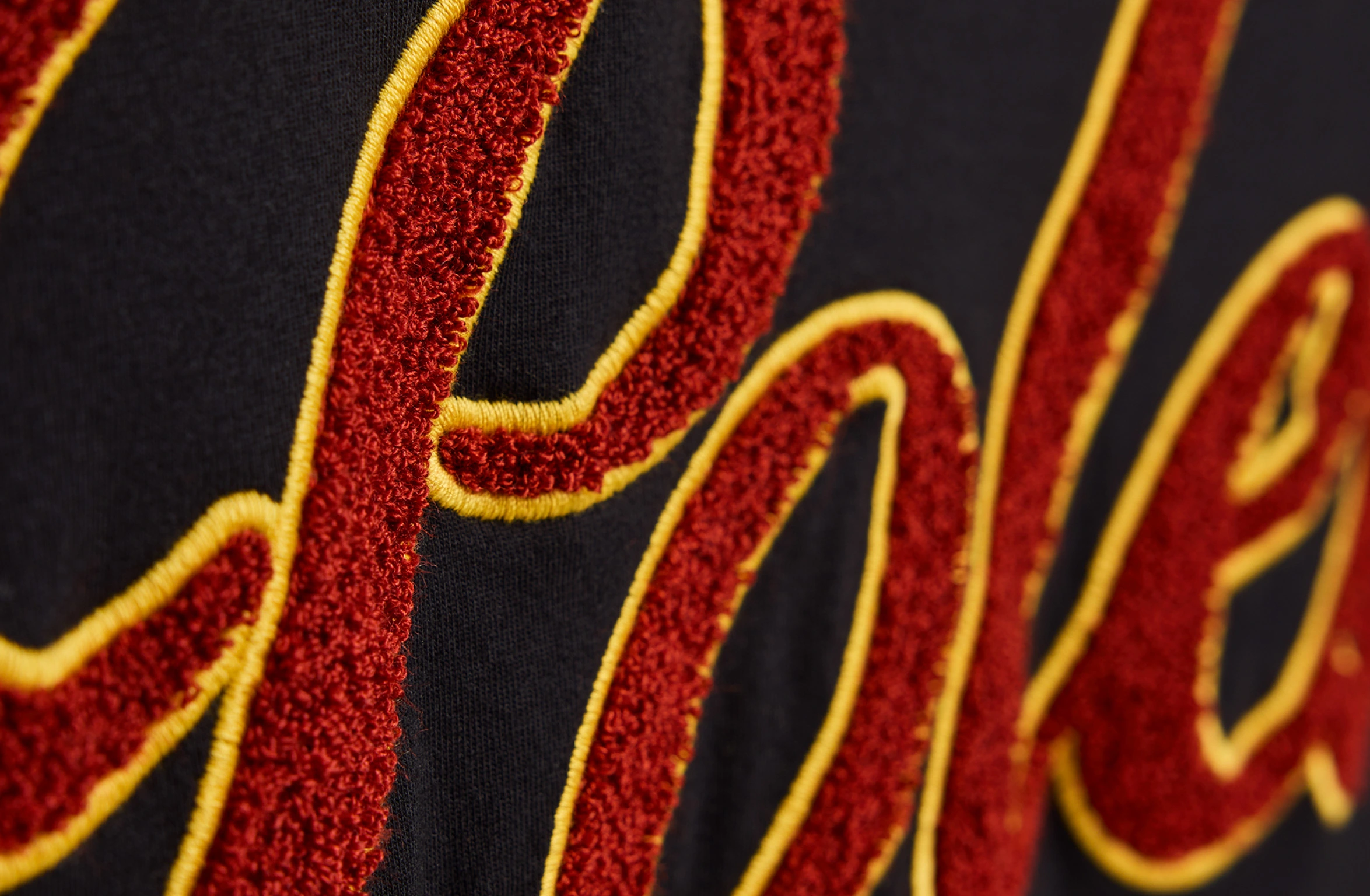 Black t-shirt with a lagre bold teddy Polestar wordmark in red and yellow across the upper back